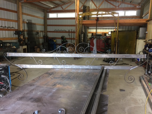 Ornate decorative scrollwork steel piece on shop floor