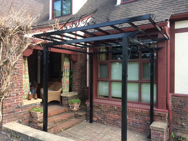 Completed decorative steel entry canopy installed on brick home exterior